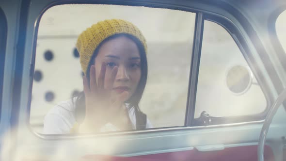 Portrait of a woman looking inside of a vintage car