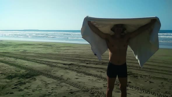 Man on the Beach Holding Towel