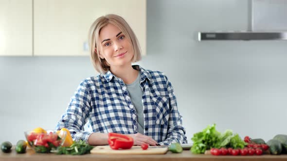 Beautiful Young Casual Housewife Posing at Kitchen During Cooking Healthy Food Looking at Camera alt