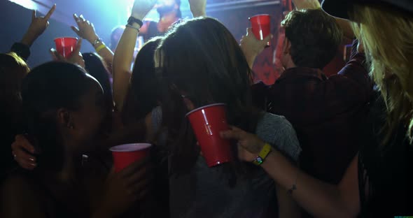 Group of people dancing at a concert 4k alt