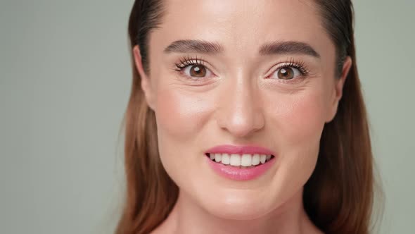 Beautiful Young Woman with Clean Fresh Skin Standing Over Light Grey Background alt