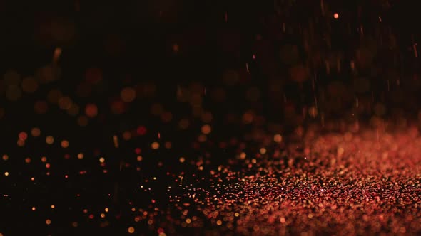 Red glitter gems spilling on black background alt