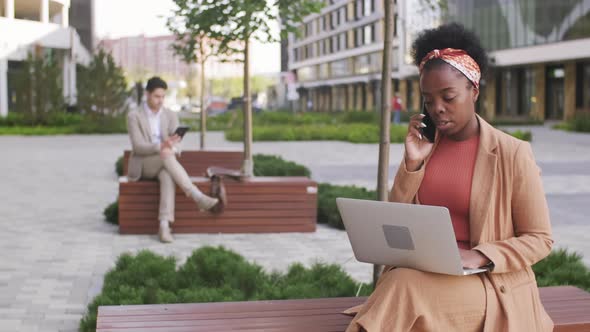  Black Businesswoman with Laptop Talking on Phone Outside alt