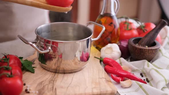 Woman Puts Tomato to Pot with Hot Boiling Water for Blanching alt