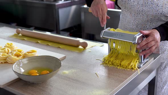 Senior woman working inside pasta factory doing fesh made tagliatelle