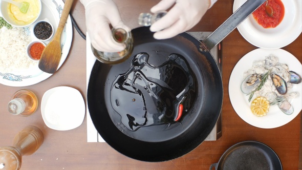 Olive oil poured into the frying pan from the bottle