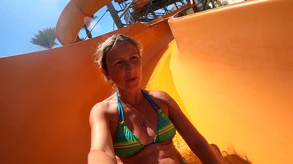 Young Woman Having Fun Going Down the Water Slides in the Water Park
