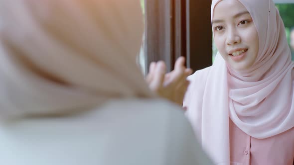 Young beautiful Asian Muslim women enjoying a relaxing moment working and playing with mobile phone alt