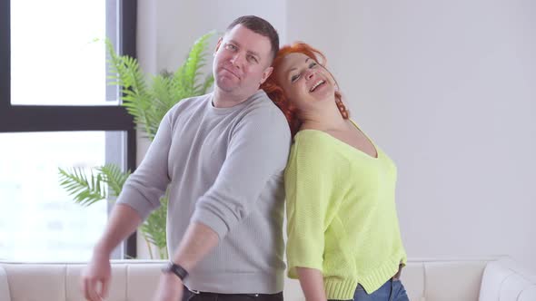 Successful Cheerful Man and Woman Making Victory Gesture Giving Highfive and Hugging Looking at alt