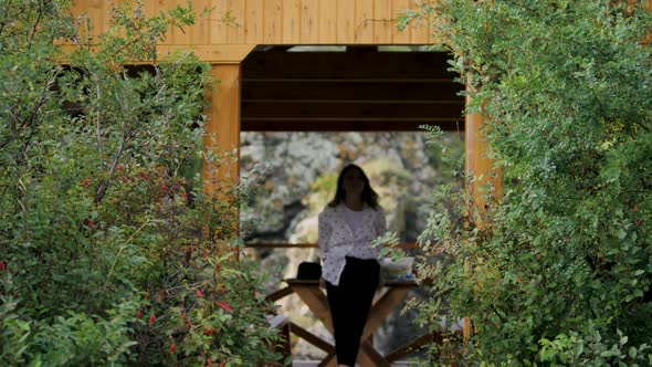 Attractive Brunette in a Hat and a White Shirt in Peas Enjoys Nature in the Mountains. on the
