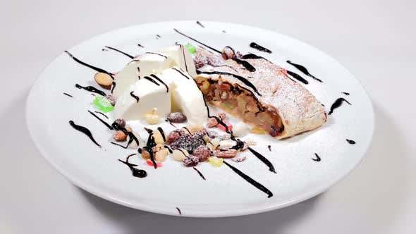 A Refreshing Dessert of Ice Cream and Sweets on a White Plate Rotates alt