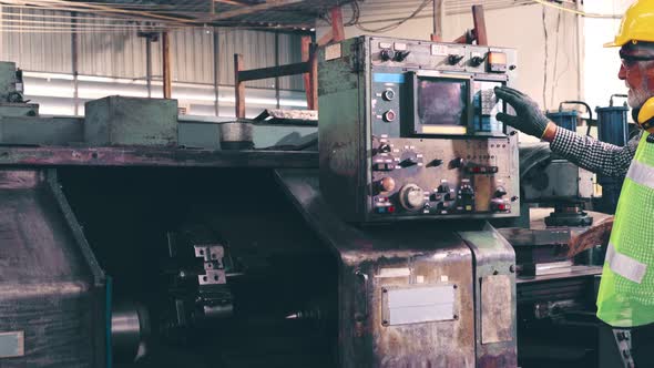 Senior Factory Worker Teach How to Use Machine Equipment in the Factory Workshop alt