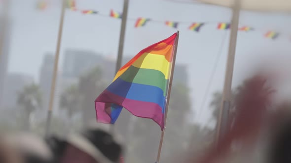 LGBTQ rainbow flag waving in slow motion during the main party in a pride parade