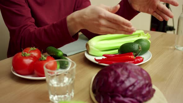 A Young Man is Showing His Friend Two Ripe Avocados alt