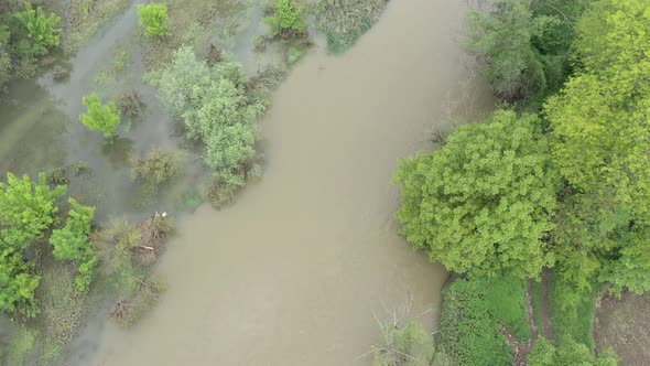 Flooded coastal area of narrow river 4K aerial footage alt