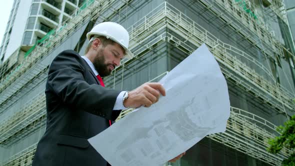 An Engineer Scientist and Developer at a Construction Site Checks on the Drawings at What Stage is alt