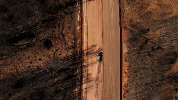 Truck with Sand Driving Along Unfinished Road Aerial alt