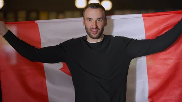 Front View Young Handsome Caucasian Man with Canadian Flag Talking Smiling Looking at Camera alt