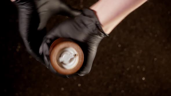 Hands in Black Gloves Spin the Mill with Pepper