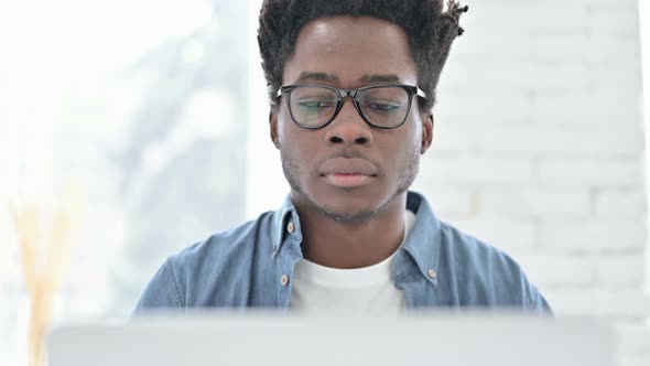 Portrait of Young African Man Celebrating on Laptop alt
