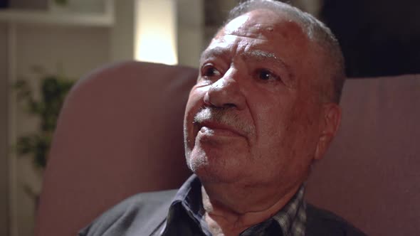 The old man laughs at the screen alt