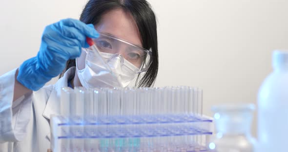 Scientist putting drops of chemical into test tube  alt