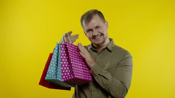 Joyful Man Showing Black Friday Inscription From Shopping Bags, Smiling Satisfied with Low Prices alt