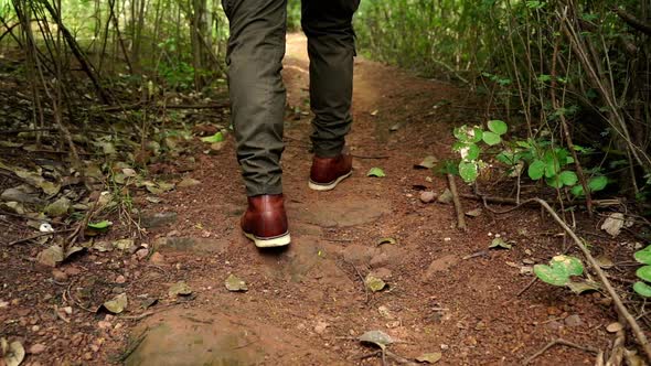 slow-motion of hiking man with trekking boots walking in the natural forest alt