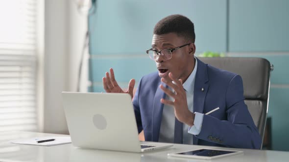Young African Businessman Reacting to Loss While Using Laptop alt