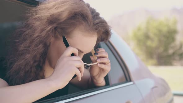 Positive Woman Puts on Sunglasses and Fixes Hair Inside Car alt