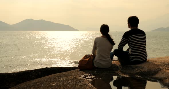 Couple Enjoy the View of Seascape Under Sunset alt