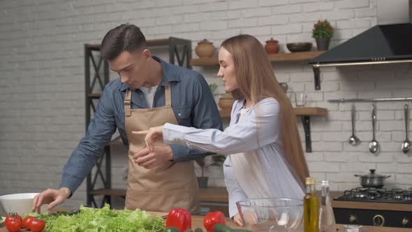 couple in love smiling, enjoying preparing healthy vegetarian food salad meal for romantic dinner alt