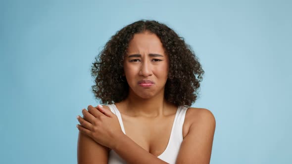 Unhappy Black Young Female Massaging Aching Shoulder Over Blue Background alt