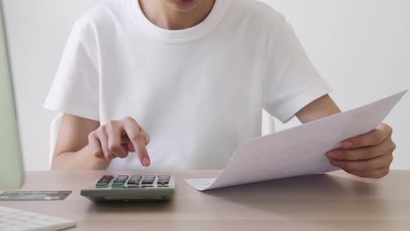 Hand press calculator to calculate income expenses and plans for spending money on home office. alt