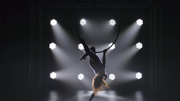 Beautiful Curly Aerial Gymnast Performs Elements on Aerial Hoop. The Graceful Silhouette of a Young alt