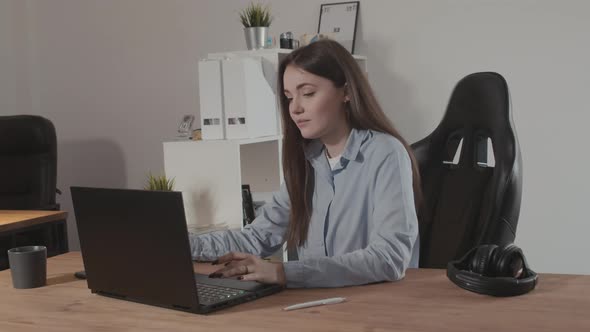 Girl in a Modern Office Working on a Laptop alt