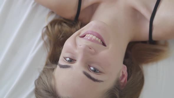 Lovely Pretty Young Happy Caucasian Woman with Different Colored Eyes Lying in Bed in the Morning alt