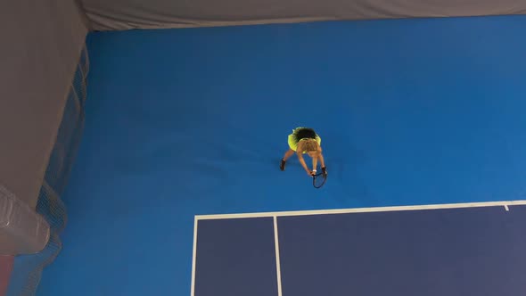 Top View of Tanned Slim Caucasian Woman Playing Tennis on Indoor Court. Confident Young Sportswoman alt