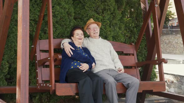 Happy elderly couple on porch swing remember the best years of their life