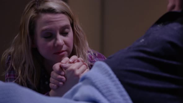 Young woman holding hand of hospital patient