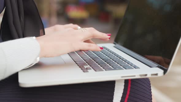 Close Up Of A Woman's Hands As She Types On Her Laptop Whilst Being Sat Outside alt
