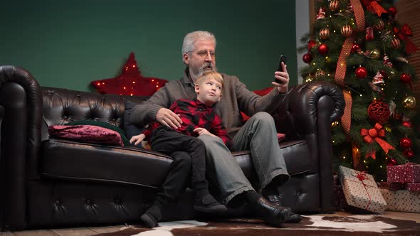 Elegant Old Man and Little Boy Talking on Video Communication on Smartphone alt