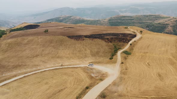 Aerial Drone Pan Shot of Hills and Road with Car Moving