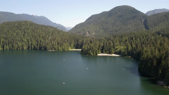 People enjoying white sand beach at Lake Belcarra Regional Park, stand up paddle boards alt
