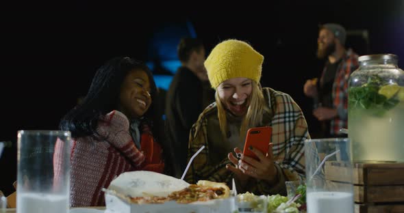 Female Best Friends Looking at Their Smartphone alt