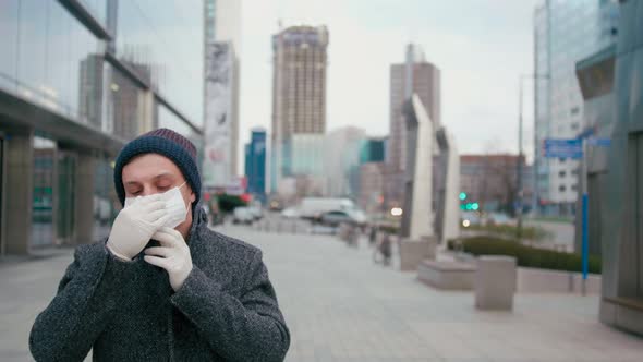 SARS-CoV-2 COVID-19 Coronavirus Pandemic Outbreak: Man Puts on Face Mask in City