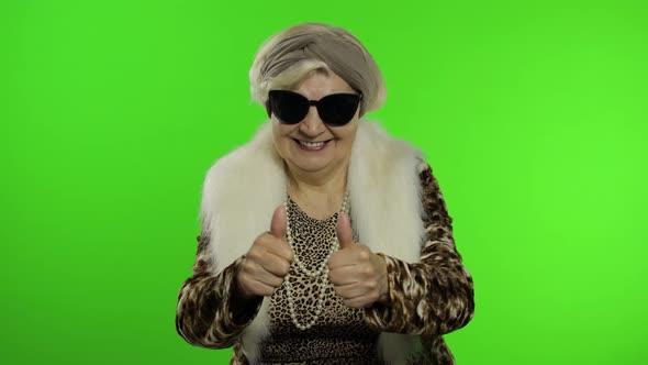 Old Style Granny Caucasian Woman Puts on Sunglasses. Chroma Key Background alt