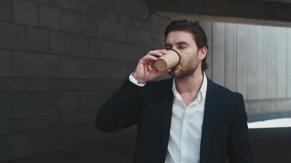 Business Man Drinking Coffee To Go outdoors.Male Professional Standing on Street alt