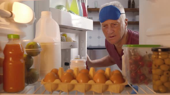 Mature Man Taking Bottle of Milk From Fridge for Breakfast alt