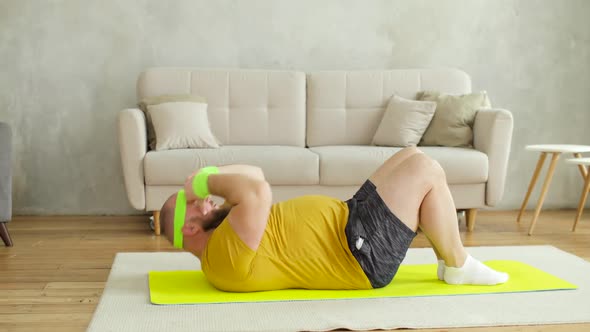 Fat Man Newcomer in Sport in Sportswear Doing Abs Exercise at Home Lying on Mat